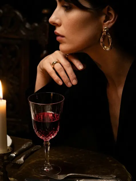 LUVA — woman with cherries and gold earrings in darkness